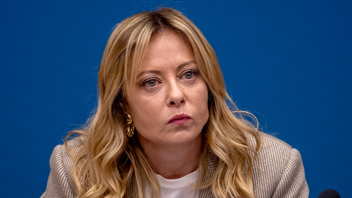 Italian Prime Minister Giorgia Meloni speaking at a podium during a press conference in Rome