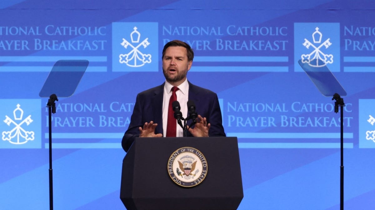 Vice President JD Vance speaking at a podium at the National Catholic Prayer Breakfast in Washington, D.C.