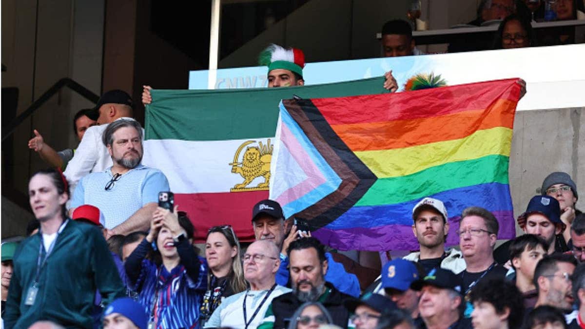 Fans wave rainbow and Iranian flags at World Cup match