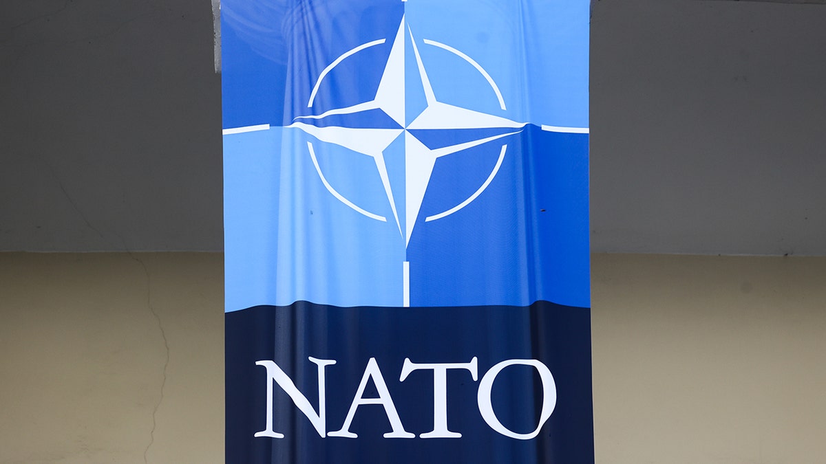 NATO emblem displayed on a blue background.
