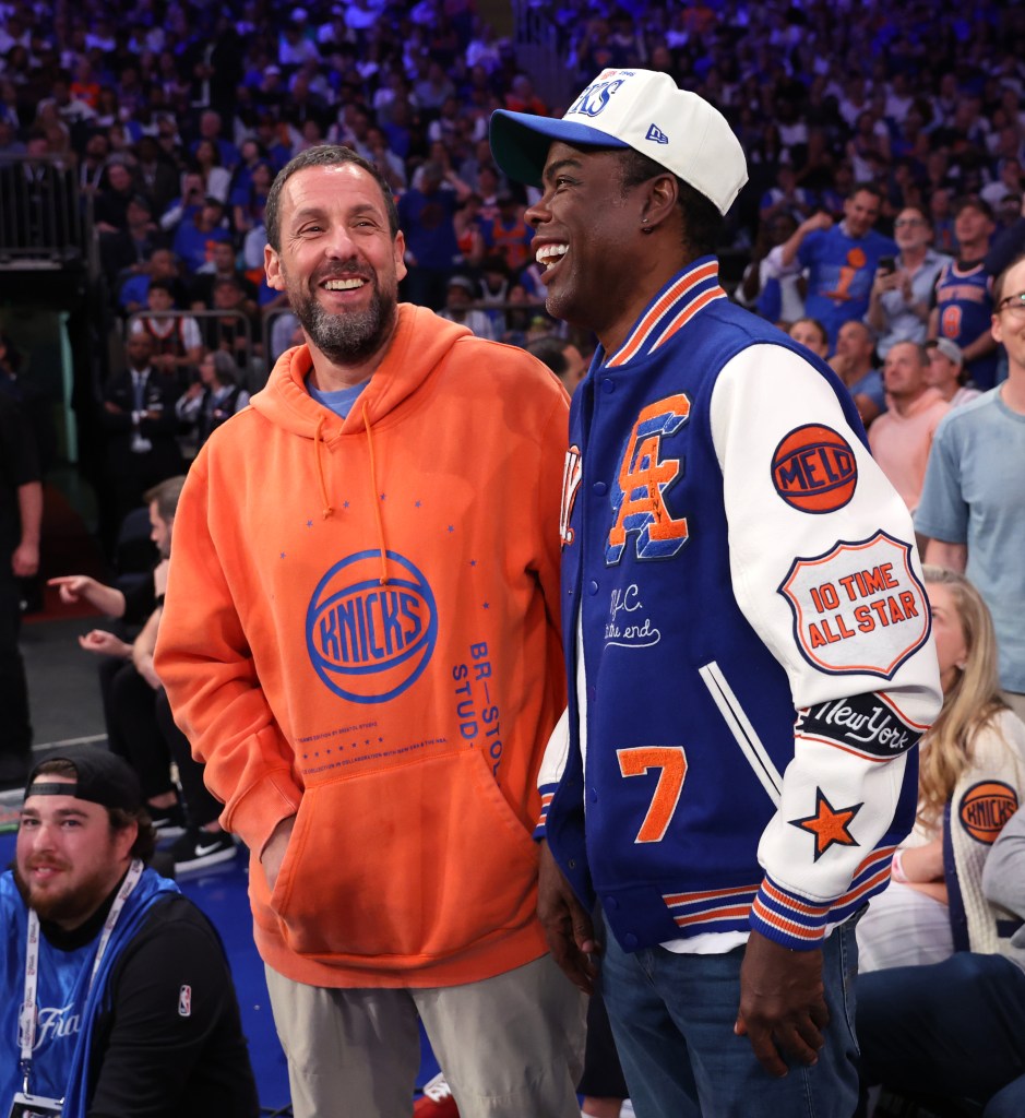 Adam Sandler and Chris Rock laughing on celebrity row at the 2026 NBA Finals.