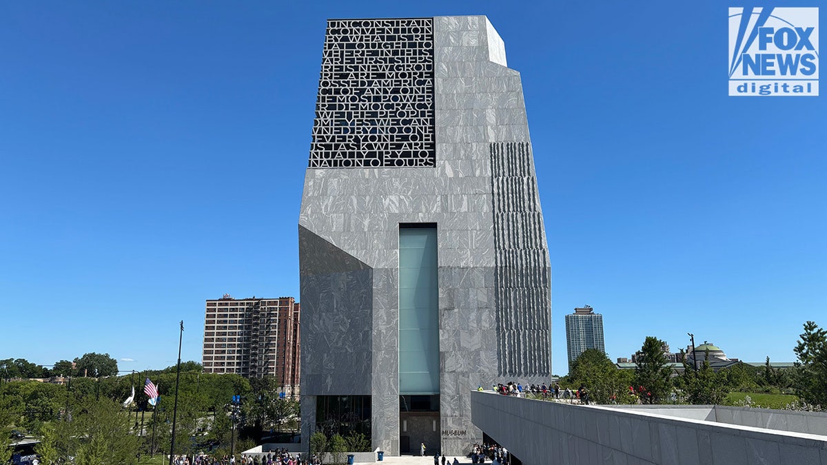 The Obama Presidential Center building with glass facade and surrounding trees.