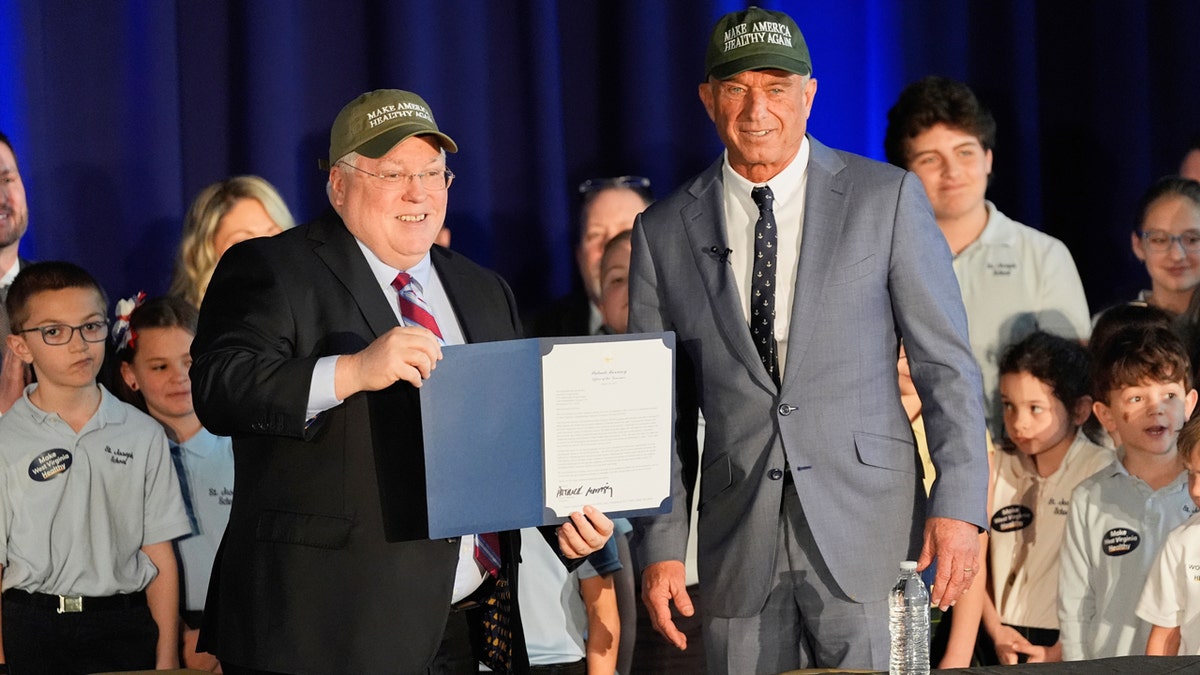 West Virginia Gov. Patrick Morrisey and Health and Human Services Secretary Robert F. Kennedy Jr. wearing Make America Healthy Again hats standing together