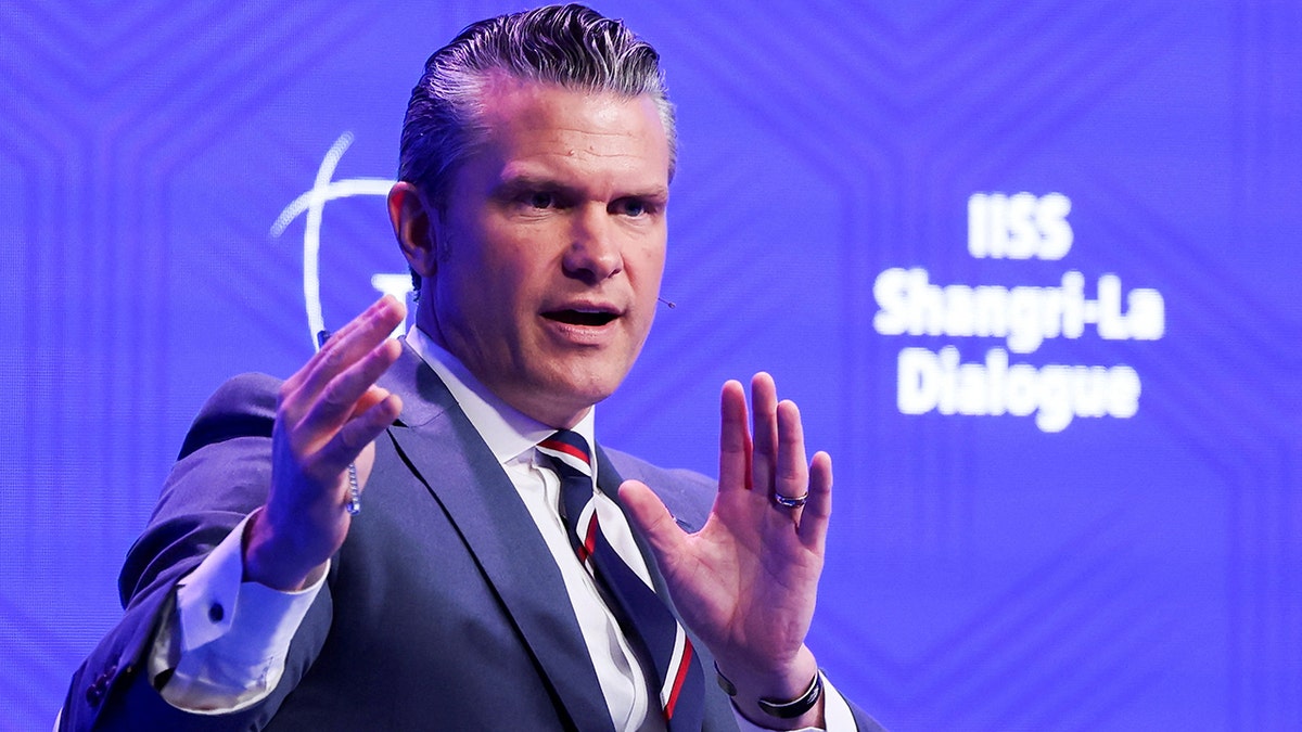 U.S. Secretary of Defense Pete Hegseth speaking at a podium at the IISS Shangri-La Dialogue in Singapore