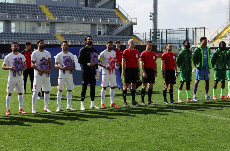 Soccer Football - International Friendly - Iran v Nigeria - Mardan Sports Complex, Antalya, Turkey - March 27, 2026 Iran's Milad Mohammadi, Hossein Kanaani, Shoja Khalilzadeh, Alireza Beiranvand and Mehdi Taremi hold school bags in memory of the victims of the girls school bombing in Minab, Iran, as they line up with the match officials and the Nigerian players before the match REUTERS/Umit Bektas