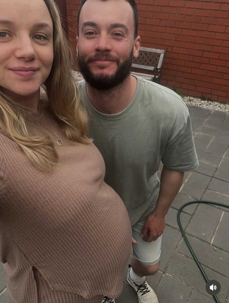 A pregnant woman and a man standing outside, the woman's pregnant belly is visible.