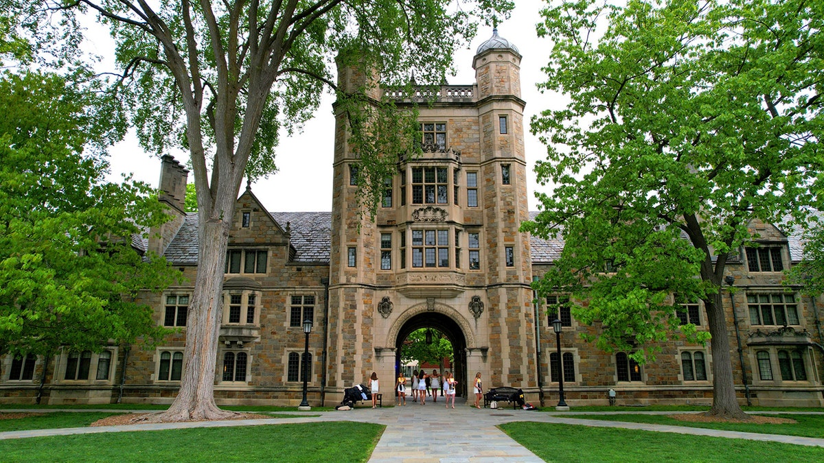 University of Michigan graduates walking through the William W. Cook Law Quadrangle passageway