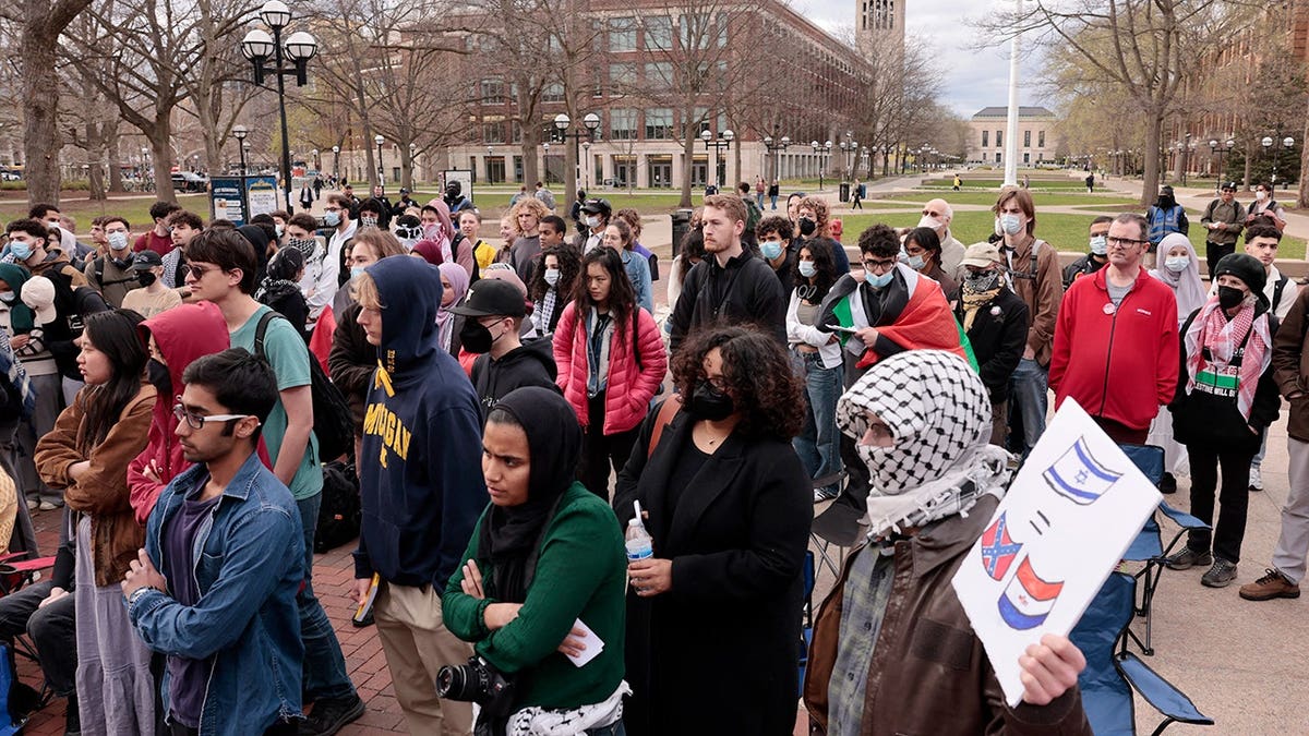 Pro-Palestinian demonstrators holding signs on University of Michigan campus in Ann Arbor