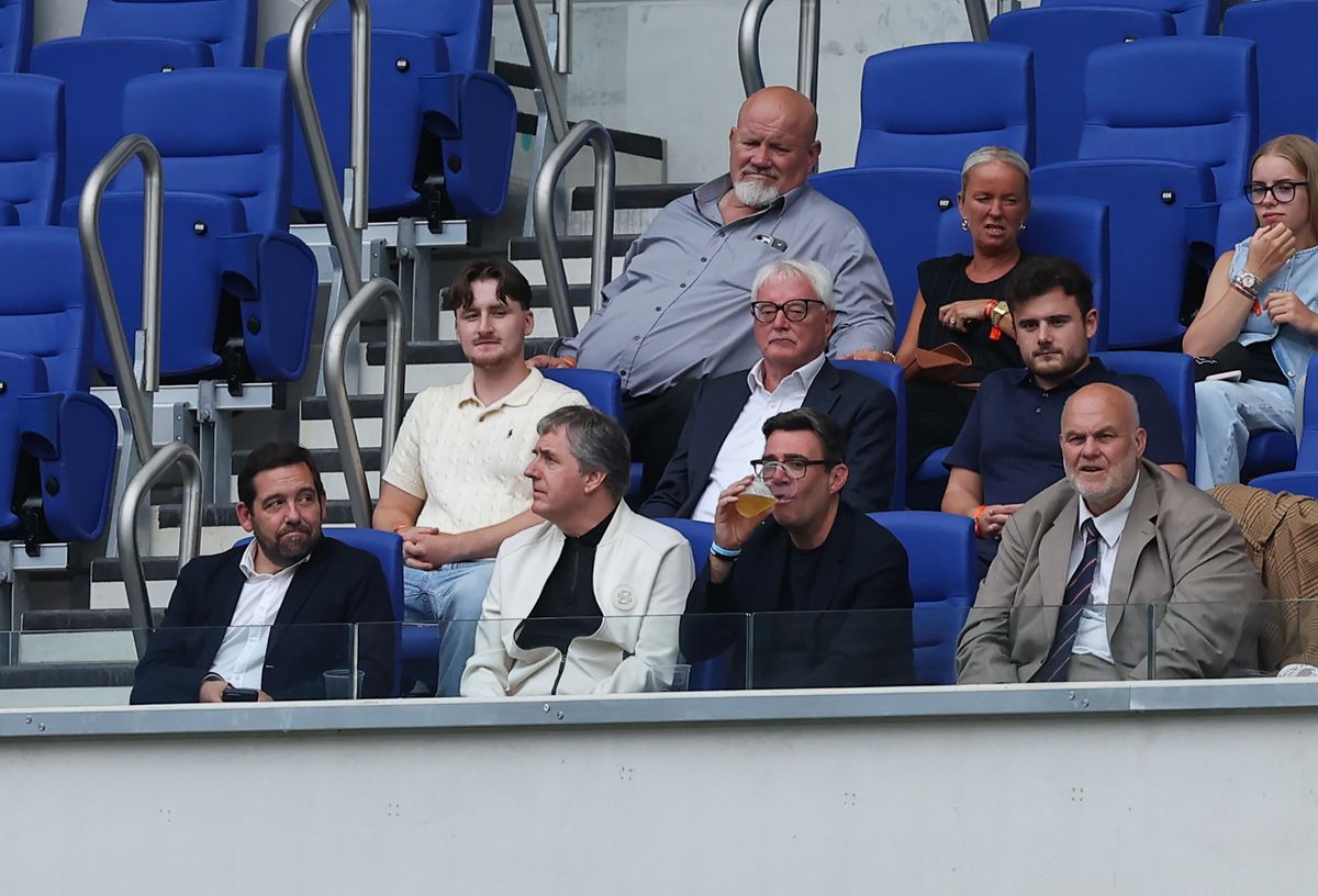 Andy Burnham enjoys a drink as he watched Leigh Leopards beat Warrington Wolves at Hill Dickinson Stadium