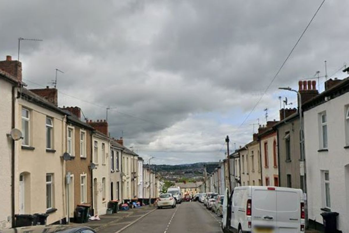 A street view of a road running central to terraced houses