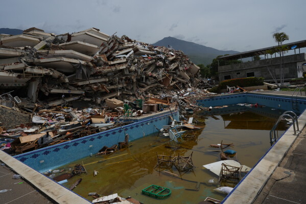 Debris floats in the swimming pool of a building that collapsed in the twin earthquakes that struck La Guaira, Venezuela, Tuesday, June 30, 2026.(AP Photo/Ariana Cubillos)