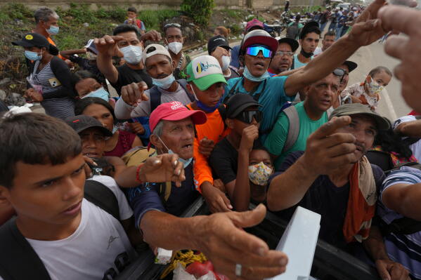 People reach out to receive supplies from volunteers, days after an earthquake struck La Guaira, Venezuela, Tuesday, June 30, 2026. (AP Photo/Matias Delacroix)