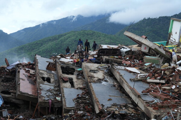 Residents search through the rubble of a building that collapsed in the earthquakes in La Guaira, Venezuela, Tuesday, June 30, 2026. (AP Photo/Ariana Cubillos)