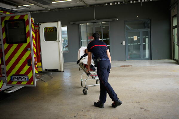 Paramedics take a patient to the emergency department of the Paris-Saclay Hospital, outside Paris, Tuesday June 30, 2026. (AP Photo/Christophe Ena )