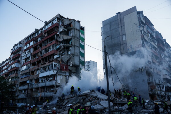 Rescue workers clear the rubble of a house heavily damaged after a Russian strike on a residential neighborhood in Kyiv, Ukraine, on Thursday, May 14, 2026. (AP Photo/Evgeniy Maloletka)