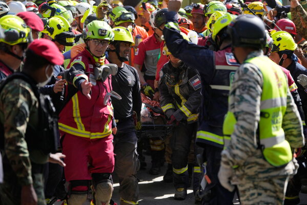 Rescue workers carry Hernán Alberto Gil Flores Gil after he was pulled from the rubble eight days after he was trapped by twin earthquakes that struck Catia La Mar, Venezuela, Thursday, July 2, 2026. (AP Photo/Fernando Vergara)