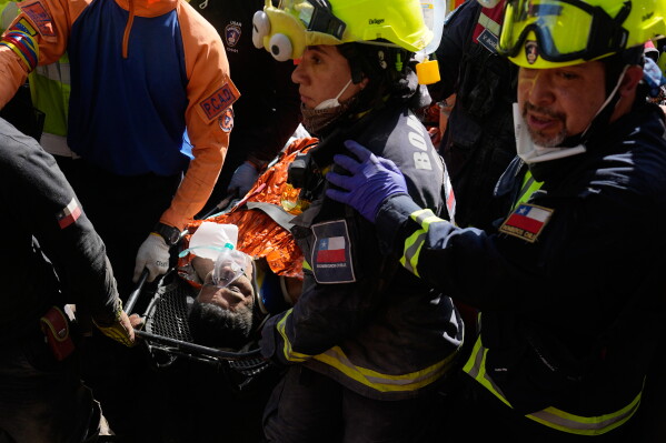 Chilean rescue workers carry Hernán Alberto Gil Flores after he was pulled from the rubble eight days after he was trapped by twin earthquakes that struck Catia La Mar, Venezuela, Thursday, July 2, 2026. (AP Photo/Fernando Vergara)