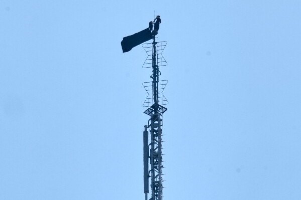 A person is shown atop the spire of the Empire State Building, in New York, Wednesday, July 1, 2026. (AP Photo/Richard Drew)