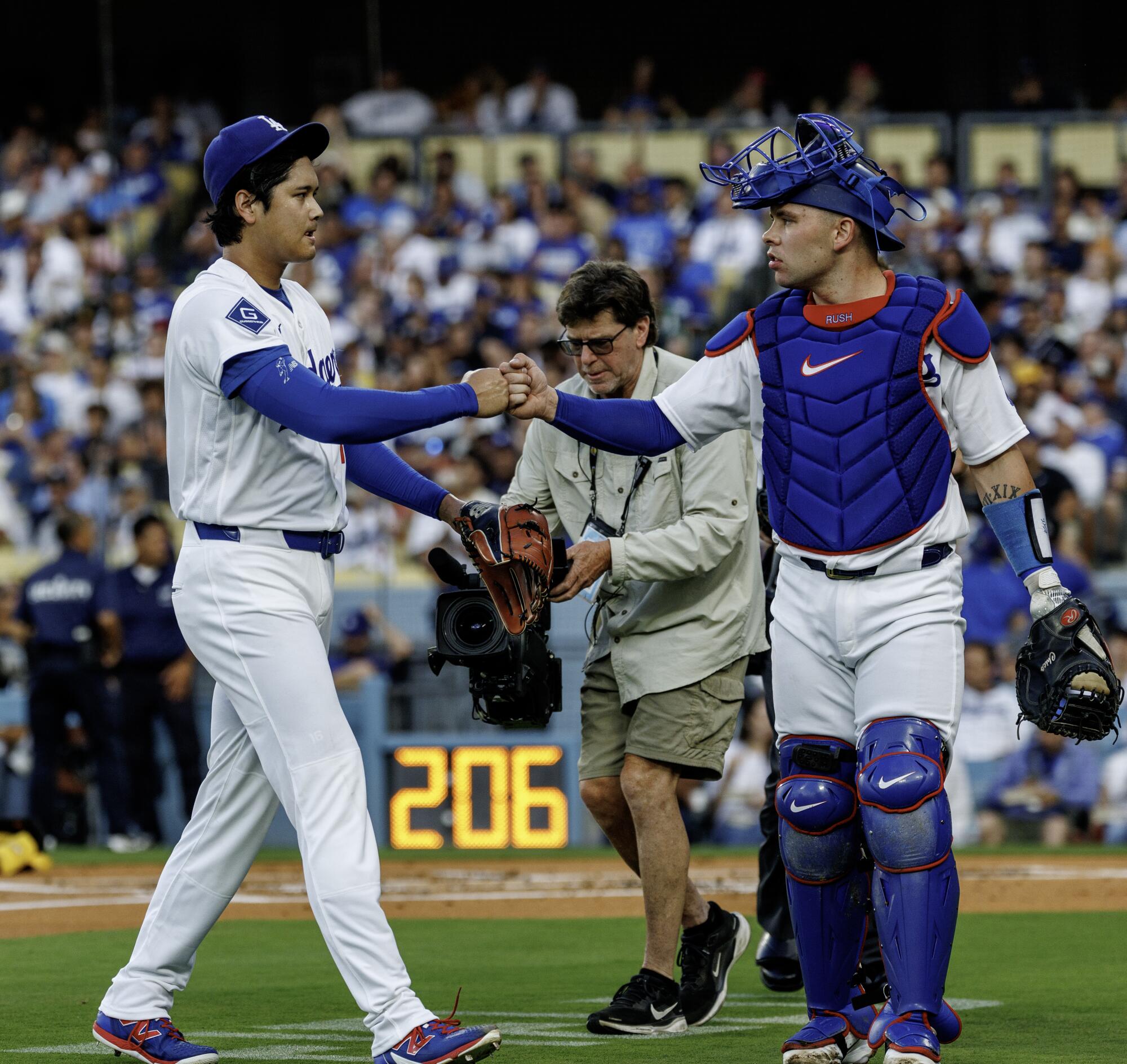 Dodgers pitcher Shohei Ohtani, left, gets a fist bump from catcher Dalton Rushing.