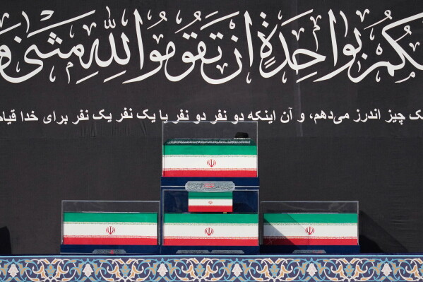The coffins of the late Iranian Supreme Leader Ayatollah Ali Khamenei and members of his family are displayed on a platform at the start of the dayslong funeral ceremonies at the Imam Khomeini Mosalla Grand Mosque in Tehran, Iran, Saturday, July 4, 2026. (AP Photo/Altaf Qadri)
