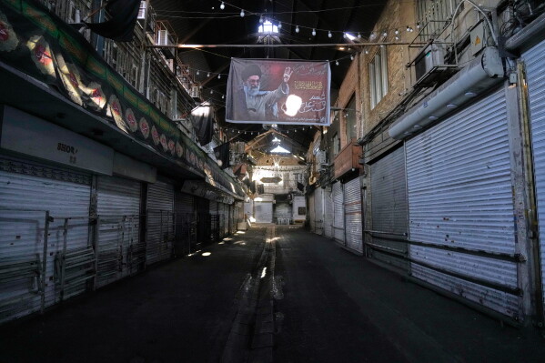 Shops are closed in Tehran old main bazaar due to the dayslong funeral ceremonies for the late Iranian Supreme Leader Ayatollah Ali Khamenei, shown in the banner on top, and members of his family, who were killed during the U.S. and Israel strike on Feb. 28, Iran, Saturday, July 4, 2026. (AP Photo/Vahid Salemi)