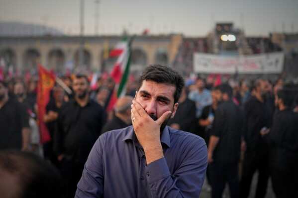 A mourner weeps during the funeral ceremonies for slain Iranian Supreme Leader Ayatollah Ali Khamenei and members of his family at the Imam Khomeini Mosalla Grand Mosque in Tehran, Iran, Saturday, July 4, 2026. (AP Photo/Altaf Qadri)