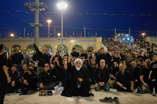 A cleric raises his fist after leading a prayer during the funeral ceremonies for slain Iranian Supreme Leader Ayatollah Ali Khamenei and members of his family at the Imam Khomeini Mosalla Grand Mosque in Tehran, Iran, Saturday, July 4, 2026. (AP Photo/Altaf Qadri)