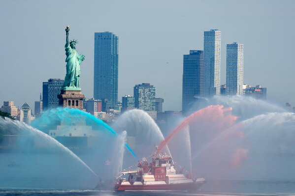 A New York Fire Department vessel sprays its water cannons in the New York harbor during ahead of Sail250, a gathering of tall ships and military ships honoring America's 250th Anniversary, Saturday, July 4, 2026, in New York. (AP Photo/Frank Franklin II)