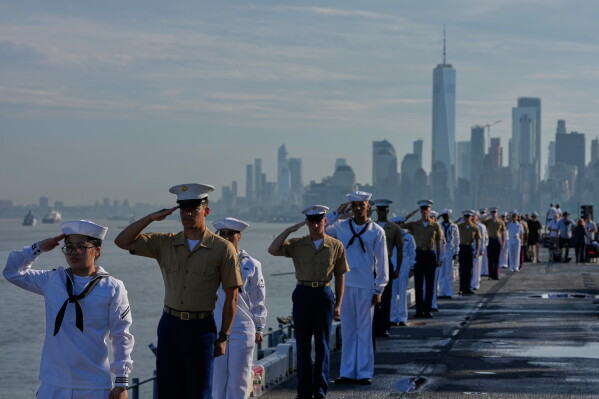Military personnel salute from the flight deck of the USS Kearsarge (LHD-3) in the New York harbor during The International Naval Review, ahead of Sail250, a gathering of tall ships and military ships honoring America's 250th Anniversary, Saturday, July 4, 2026, in New York. (AP Photo/Frank Franklin II)