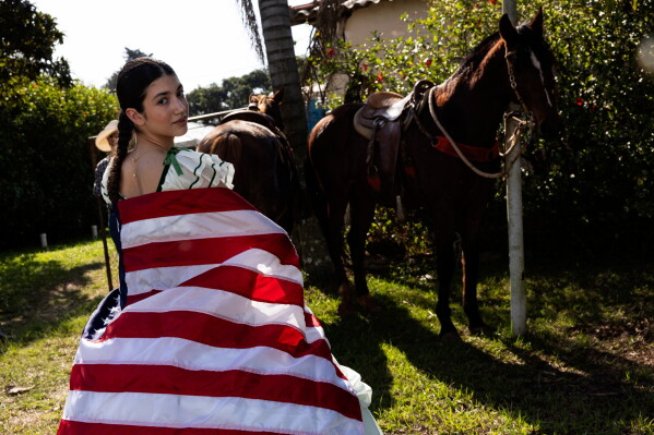 A participant wearing a period dress draped in a U.S. flag attends the annual Festa Americana, where descendants of American immigrants in Brazil celebrate their U.S. heritage and mark Independence Day, in Santa Barbara d'Oeste, Brazil, Saturday, July 4, 2026. (AP Photo/Ettore Chiereguini)