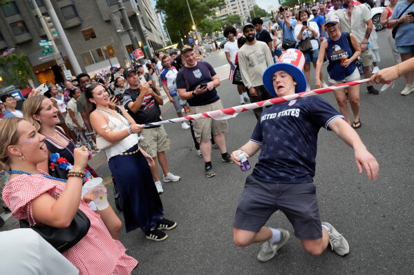 People participate in a Limbo contest as they wait for the National Mall to reopen after being evacuated due to weather during Independence Day events honoring the nation's 250th anniversary, Saturday, July 4, 2026, in Washington. (AP Photo/Pablo Martinez Monsivais)