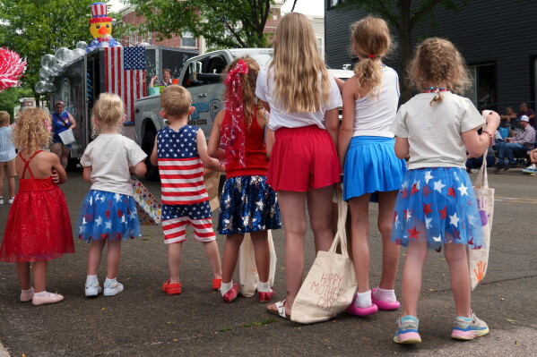 Children line up to watch an Independence Day parade, Saturday, July 4, 2026, in Deforest, Wis. (AP Photo/Jon Elswick)