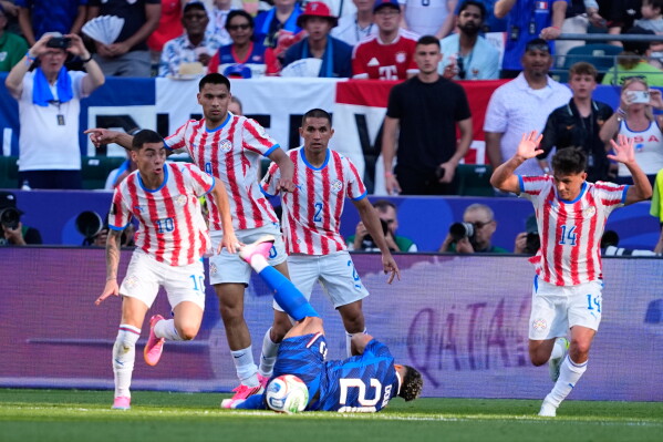 Paraguay's Miguel Almiron (10) controls the ball as France's Desire Doue falls during the World Cup round of 16 soccer match in Philadelphia, Saturday, July 4, 2026. (AP Photo/Petr David Josek)