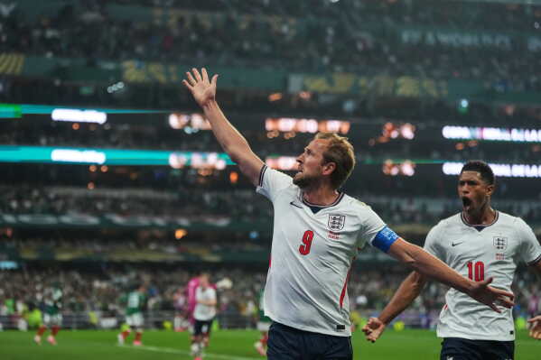 England's Harry Kane (9) celebrates with Jude Bellingham (10) after scoring his side's third goal through penalty kick during the World Cup round of 16 soccer match between Mexico and England in Mexico City, Sunday, July 5, 2026. (AP Photo/Eduardo Verdugo)