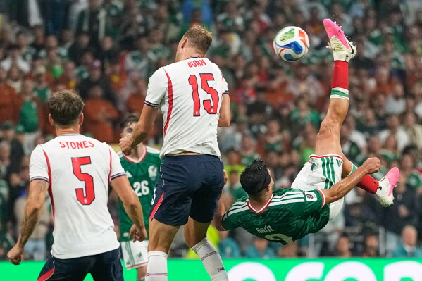 Mexico's Raul Jimenez (9) attempts an overhead kick at goal as England's Dan Burn (15) defends during the World Cup round of 16 soccer match between Mexico and England in Mexico City, Sunday, July 5, 2026. (AP Photo/Natacha Pisarenko)
