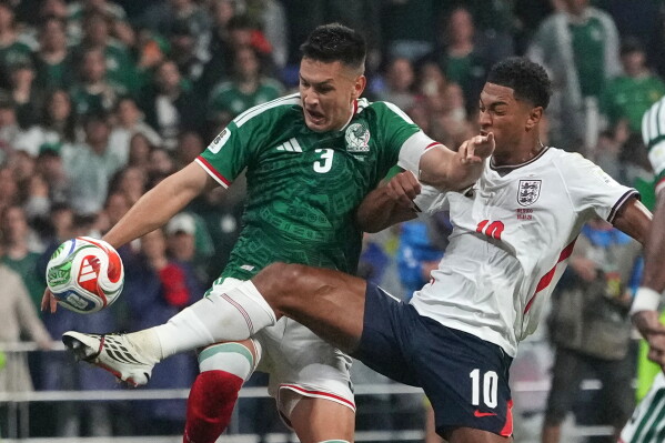 England's Jude Bellingham (10) battles for the ball with Mexico's Cesar Montes (3) during the World Cup round of 16 soccer match between Mexico and England in Mexico City, Sunday, July 5, 2026. (AP Photo/Eduardo Verdugo)