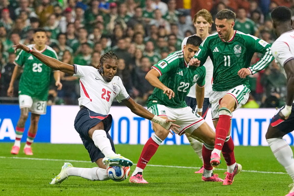 England's Djed Spence (25) blocks a shot from Mexico's Santiago Gimenez (11) during the World Cup round of 16 soccer match between Mexico and England in Mexico City, Sunday, July 5, 2026. (AP Photo/Natacha Pisarenko)