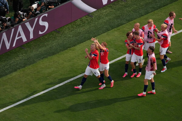 Norway’s Andreas Schjelderup (21) crowns Erling Haaland (9) as others celebrate after Haaland scored their second goal during the World Cup round of 16 soccer match between Brazil and Norway in East Rutherford, N.J., near New York, Sunday, July 5, 2026. (AP Photo/Matt Slocum)