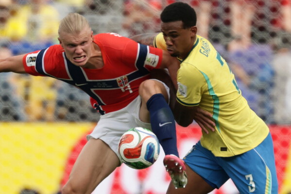 Norway's Erling Haaland (9) fights for the ball with Brazil's Gabriel Magalhaes (3) during the World Cup round of 16 soccer match between Brazil and Norway in East Rutherford, N.J., near New York, Sunday, July 5, 2026. (AP Photo/Adam Hunger)