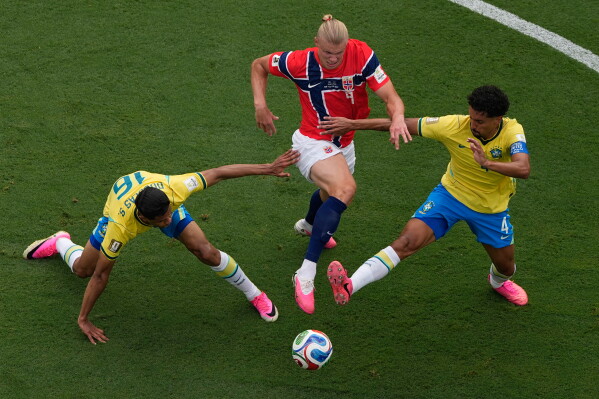 Norway's Erling Haaland (9) battles for the ball with Brazil's Douglas Santos (16) and Marquinhos (4) during the World Cup round of 16 soccer match between Brazil and Norway in East Rutherford, N.J., near New York, Sunday, July 5, 2026. (AP Photo/Matt Slocum)