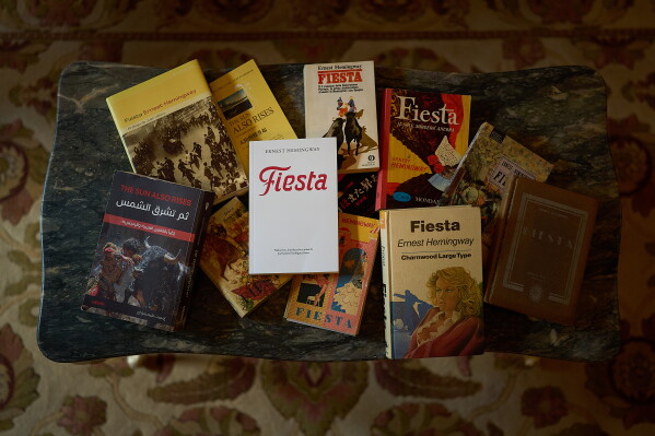Copies of "The Sun Also Rises," most featuring its translated and overseas title, are photographed in the Ernest Hemingway Suite at the Gran Hotel La Perla in Pamplona, northern Spain, Thursday, July 2, 2026. (AP Photo/Miguel Oses)