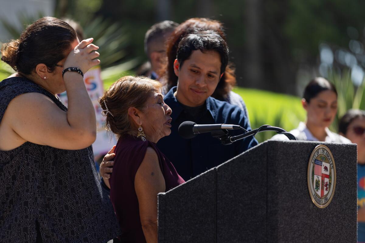 Street vendor Arabelia Martinez speaks with her son, Jose Garcia, at a press conference.