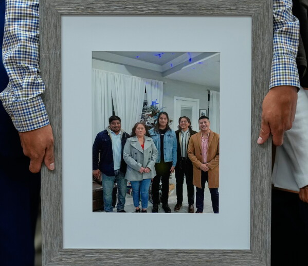 Lorenzo Salgado Jr., son of Lorenzo Salgado Araujo, holds a family photograph during a news conference Wednesday, July 8, 2026, in Houston. (AP Photo/David J. Phillip)