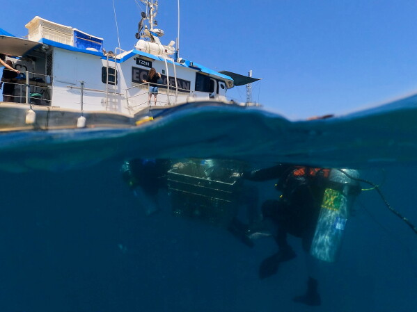 Divers descend to place mock munitions on the floor of the Mediterranean Sea off the coast of Rishon LeZion, Israel, Sunday, June 21, 2026. (AP Photo/Ariel Schalit)