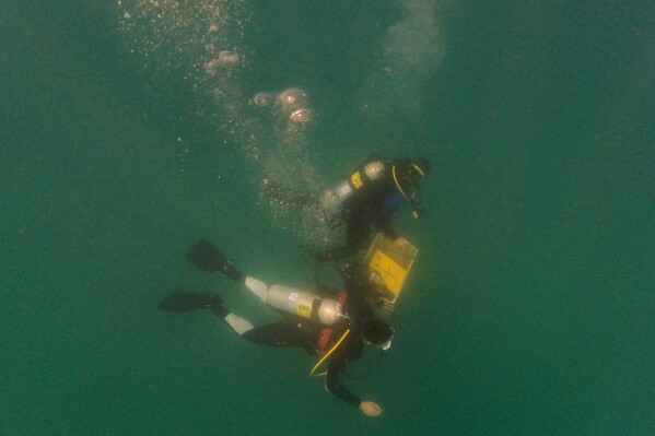 Divers place mock munitions on the floor of the Mediterranean Sea off the coast of Rishon LeZion, Israel, Sunday, June 21, 2026. (AP Photo/Ariel Schalit)
