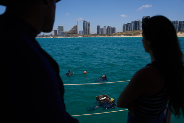 Divers place mock munitions on the floor of the Mediterranean Sea off the coast of Rishon LeZion, Israel, Sunday, June 21, 2026. (AP Photo/Ariel Schalit)
