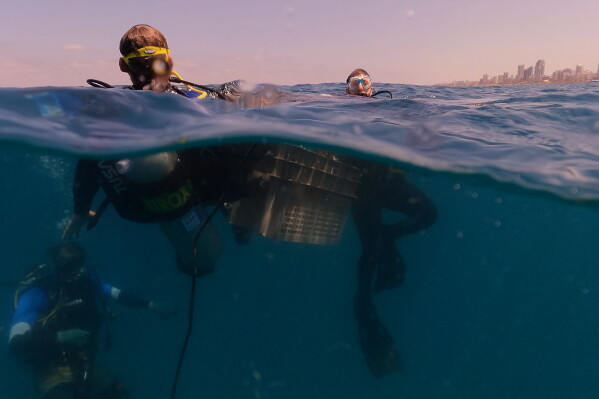 Divers descend to place mock munitions on the floor of the Mediterranean Sea off the coast of Rishon LeZion, Israel, Sunday, June 21, 2026. (AP Photo/Ariel Schalit)