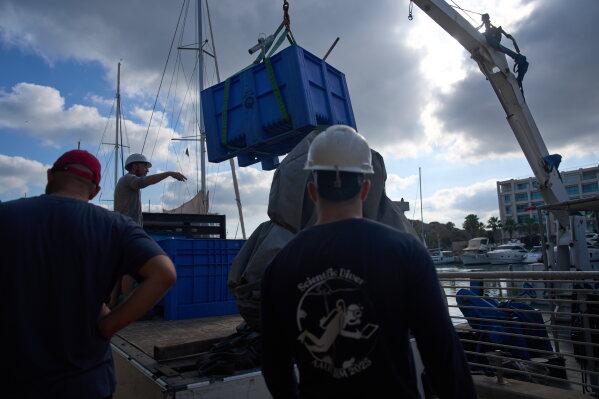 Divers load gear and mock munitions to be placed on the floor of the Mediterranean Sea off the coast of Rishon LeZion, Israel, Sunday, June 21, 2026. (AP Photo/Ariel Schalit)