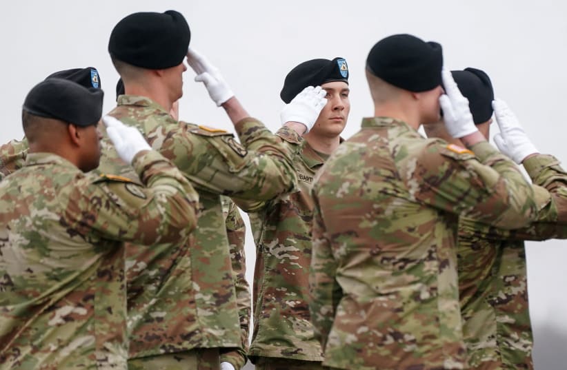 Members of the military salute during a dignified transfer of the remains of six US Army service members of the 103rd Sustainment Command, who were killed in Kuwait, at Dover Air Force Base in Dover, Delaware, US, March 7, 2026.