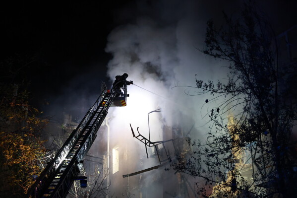 Rescue workers try to put out a fire of a residential building burning after a Russian drone attack on Zaporizhzhia, Ukraine, late Sunday, July 12, 2026. (AP Photo/Kateryna Klochko)
